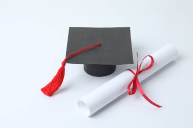 Mezuniyet konsepti. Diploma ve beyaz arkaplan üzerine kitap içeren düz kare akademik başlık.