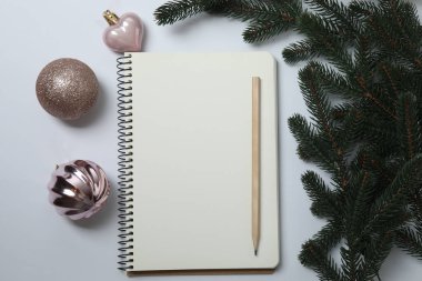 Yeni yıl ve noel arkaplanı defter, noel ağacı ve beyaz zemin üzerindeki süslemeler, üst görünüm, kopyalama alanı.
