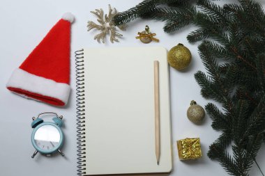 Yeni yıl ve noel arkaplanı defter, noel ağacı ve beyaz zemin üzerindeki süslemeler, üst görünüm, kopyalama alanı.