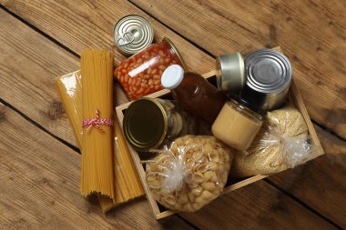 İnsani yardım. Tahta masa üzerinde bağış yapmak için farklı gıda ürünleri.