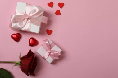 Kırmızı kurdelelere sarılı, pembe arka planda kırmızı kalplerle çevrili sevgililer günü afişi. Romantik ve şenlikli etkinlikler için ideal.