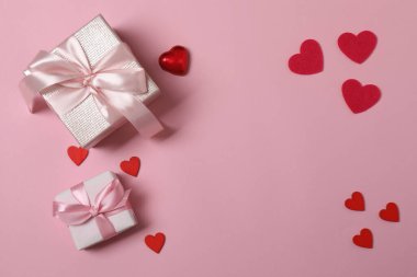 Kırmızı kurdelelere sarılı, pembe arka planda kırmızı kalplerle çevrili sevgililer günü afişi. Romantik ve şenlikli etkinlikler için ideal.