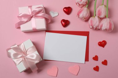 Pembe laleler, hediye kutusu ve renk arka planında kalpler.