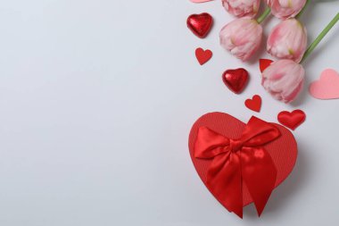 Pembe laleler, hediye kutusu ve renk arka planında kalpler.