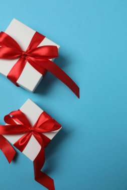 Kırmızı kurdelelere sarılı, mavi arka planda kırmızı kalplerle çevrili sevgililer günü afişi. Romantik ve şenlikli etkinlikler için ideal.