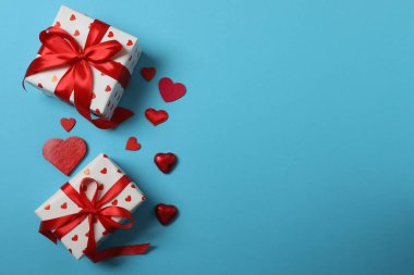 Kırmızı kurdelelere sarılı, mavi arka planda kırmızı kalplerle çevrili sevgililer günü afişi. Romantik ve şenlikli etkinlikler için ideal.