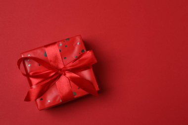 Kırmızı kurdelelere sarılı, kırmızı kalplerle çevrili hediye kutularıyla Sevgililer Günü afişi. Romantik ve şenlikli etkinlikler için ideal.