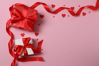 Pembe arka planda kırmızı kalplerle çevrili Sevgililer Günü afişi. Romantik ve şenlikli olaylar için mükemmel..