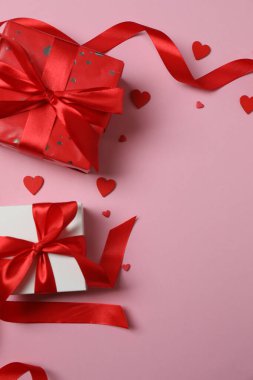 Pembe arka planda kırmızı kalplerle çevrili Sevgililer Günü afişi. Romantik ve şenlikli olaylar için mükemmel..