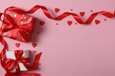 Pembe arka planda kırmızı kalplerle çevrili Sevgililer Günü afişi. Romantik ve şenlikli olaylar için mükemmel..