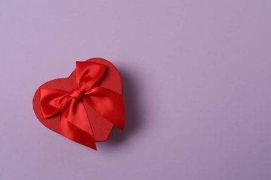 Renkli arka planda kırmızı kalplerle çevrili hediye kutularıyla Sevgililer Günü afişi. Romantik ve şenlikli olaylar için mükemmel..