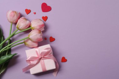 Renkli arka planda kırmızı kalplerle çevrili hediye kutularıyla Sevgililer Günü afişi. Romantik ve şenlikli olaylar için mükemmel..