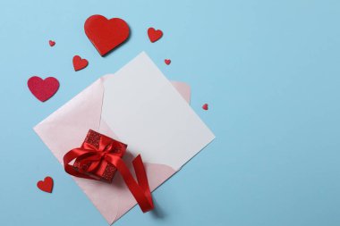 Mavi arka planda kırmızı kalplerle çevrili Sevgililer Günü afişi. Romantik ve şenlikli olaylar için mükemmel..