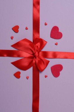 Renkli arka planda kırmızı kurdeleli parlak bir fiyonk.