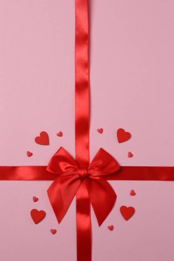 Renkli arka planda kırmızı kurdeleli parlak bir fiyonk.