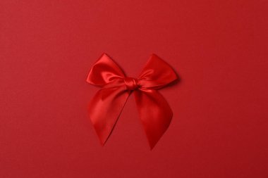 Renkli arka planda kırmızı kurdeleli parlak bir fiyonk.