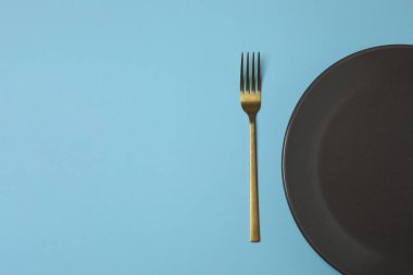 Renkli arka planda boş tabak ve çatal bıçak takımı, üst görünüm