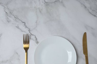 Renkli arka planda boş tabak ve çatal bıçak takımı, üst görünüm