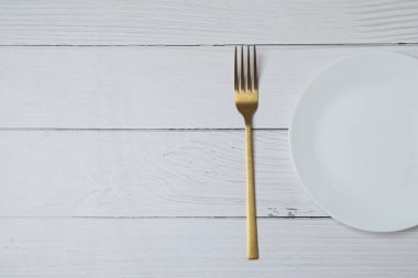 Renkli arka planda boş tabak ve çatal bıçak takımı, üst görünüm