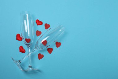 Bir şişe şampanya, iki bardak ve kupa ve hediye kutularıyla şenlik arka planı. Sevgililer gününde romantik bir randevu.