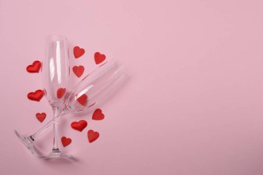 Bir şişe şampanya, iki bardak ve kupa ve hediye kutularıyla şenlik arka planı. Sevgililer gününde romantik bir randevu.