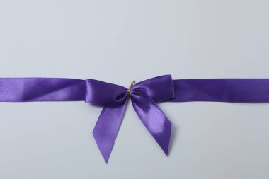 Renkli bir arka planda mor kurdeleli parlak bir yay.