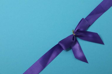 Renkli bir arka planda mor kurdeleli parlak bir yay.