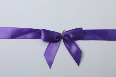 Renkli bir arka planda mor kurdeleli parlak bir yay.