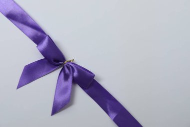 Renkli bir arka planda mor kurdeleli parlak bir yay.