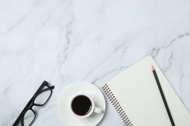 Kalem ve kahveyle masaya yaylı not defteri. Ofis kavramı. Üst görünüm.