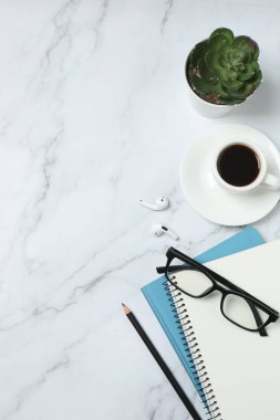 Kalem ve kahveyle masaya yaylı not defteri. Ofis kavramı. Üst görünüm.