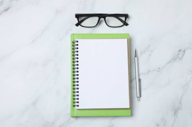 Kalem ve kahveyle masaya yaylı not defteri. Ofis kavramı. Üst görünüm.