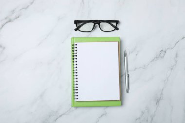 Kalem ve kahveyle masaya yaylı not defteri. Ofis kavramı. Üst görünüm.