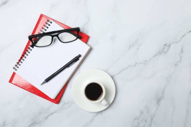 Kalem ve kahveyle masaya yaylı not defteri. Ofis kavramı. Üst görünüm.