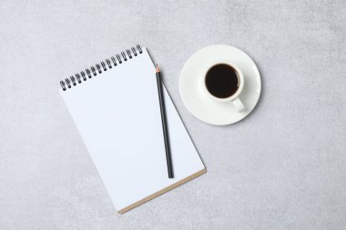 Kalem ve kahveyle masaya yaylı not defteri. Ofis kavramı. Üst görünüm.