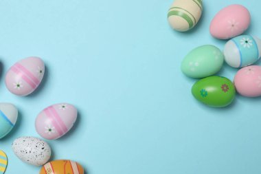Renkli Paskalya yumurtaları ve bahar çiçekleri. metin için alanı olan mavi bir arkaplan üzerinde