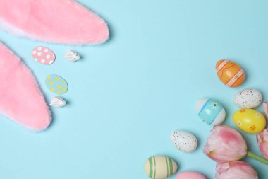 Renkli Paskalya yumurtaları ve bahar çiçekleri. metin için alanı olan mavi bir arkaplan üzerinde