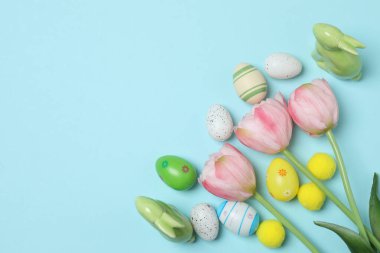 Renkli Paskalya yumurtaları ve bahar çiçekleri. metin için alanı olan mavi bir arkaplan üzerinde
