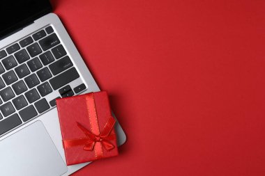 Gift box and laptop on office desk table. Top view flat lay with blank greeting card for your greetings. Valentines day