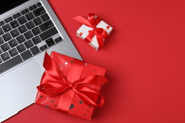 Gift box and laptop on office desk table. Top view flat lay with blank greeting card for your greetings. Valentines day