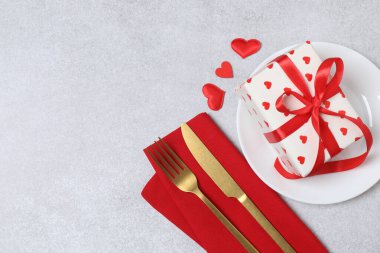 Tabak, çatal, bıçak, hediye kutusu ve kırmızı kalp ile Sevgililer Günü masa örtüsü arka plan fotokopi alanı