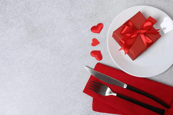 Tabak, çatal, bıçak, hediye kutusu ve kırmızı kalp ile Sevgililer Günü masa örtüsü arka plan fotokopi alanı