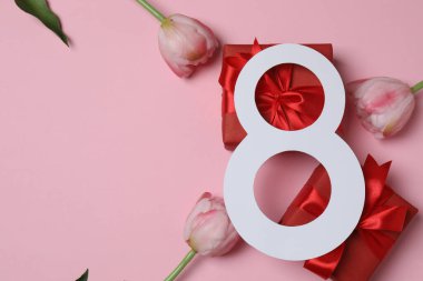 Kağıt figür 8, güzel laleler ve pembe arka planda hediye kutusu. Uluslararası Kadınlar Günü