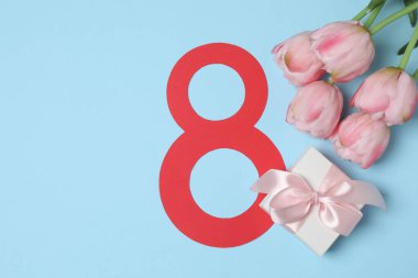 Kağıt figür 8, güzel laleler ve mavi arka planda hediye kutusu. Uluslararası Kadınlar Günü