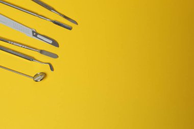 Sarı arkaplan üzerinde temizlik ve inceleme araçları ile diş modeli, PNG