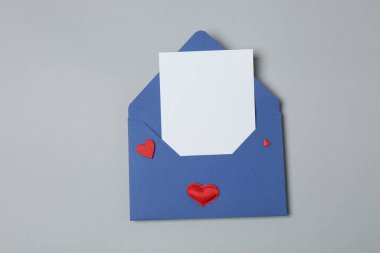 Sevgililer Günün kutlu olsun. Tebrik kartı ve gri arka planda dekoratif kalp ile zarf, üst görünüm