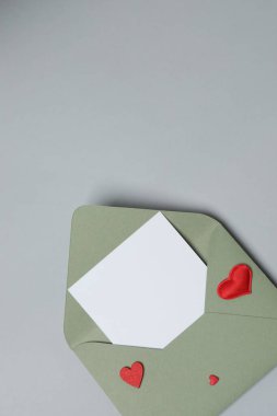 Sevgililer Günün kutlu olsun. Tebrik kartı ve gri arka planda dekoratif kalp ile zarf, üst görünüm