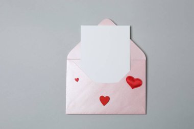 Sevgililer Günün kutlu olsun. Tebrik kartı ve gri arka planda dekoratif kalp ile zarf, üst görünüm