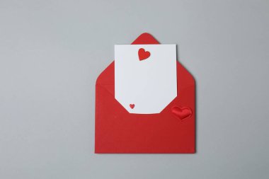 Sevgililer Günün kutlu olsun. Tebrik kartı ve gri arka planda dekoratif kalp ile zarf, üst görünüm