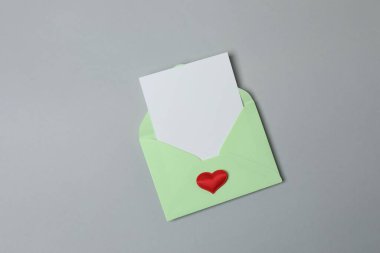 Sevgililer Günün kutlu olsun. Tebrik kartı ve gri arka planda dekoratif kalp ile zarf, üst görünüm